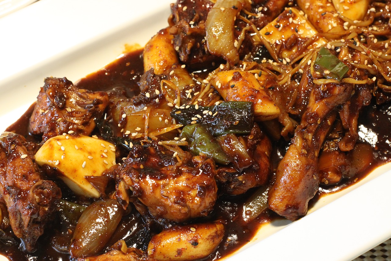 Emeril's Bourbon Braised Chicken and Apple Sausage With Onions